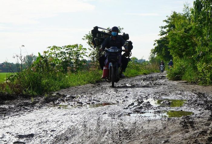 Người dân rất khó khăn lưu thông trên đường vì lầy lội, trơn trượt trong mùa mưa. Ảnh: Nhựt An - TTXVN