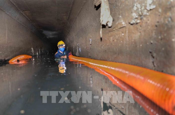 Xí nghiệp Thi công cơ giới xây lắp (Công ty Thoát nước Hà Nội) nạo vét tuyến cống Xuân Tảo (1,5x2m) bằng cơ giới kết hợp thủ công. Với 5 tổ thực hiện, công nhân trực tiếp xuống cống vận hành vòi hút, xử lý khoảng 1.000m³ bùn mỗi đợt, đảm bảo thoát nước mùa mưa. Ảnh: Phan Phương – TTXVN