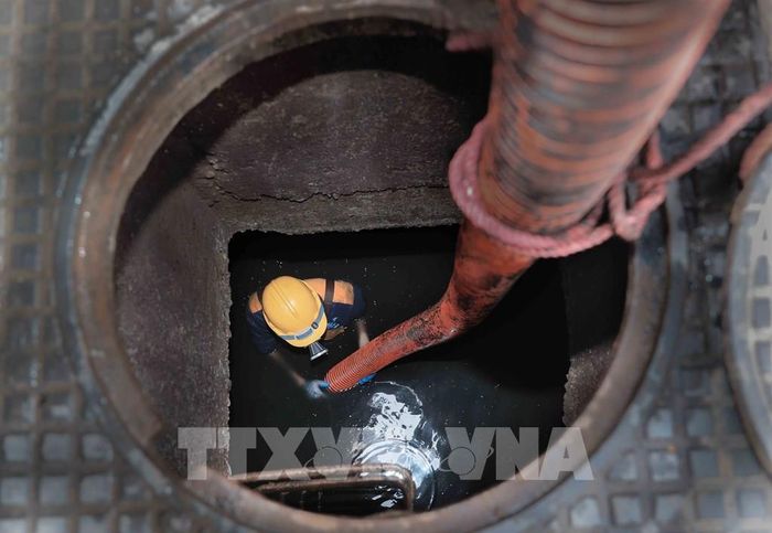 Thi công trong môi trường độc hại, tiềm ẩn nhiều nguy cơ, những người công nhân thầm lặng góp phần xây dựng Thủ đô ngày càng sạch đẹp, hiện đại. Ảnh: Phan Phương – TTXVN