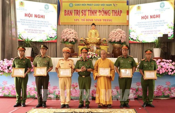 Đại tá Trần Văn Tròn, Phó Giám đốc Công an tỉnh Đồng Tháp trao bằng khen cho 6 tập thể có thành tích xuất sắc trong công tác tuyên truyền vận động tăng, ni, phật tử tham gia đảm bảo trật tự an toàn giao thông. Ảnh: Hồng Nhung - TTXVN