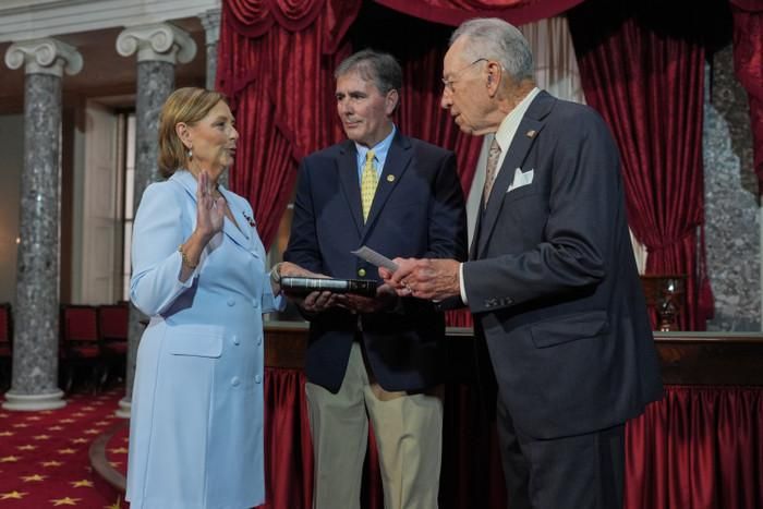 Bà Darline Graham, em gái của Thượng nghị sĩ Lindsey Graham, thuộc đảng Cộng hòa bang Nam Carolina, đã tuyên thệ nhậm chức trước Chủ tịch Thượng viện lâm thời, ông Chuck Grassley, thuộc đảng Cộng hòa bang Iowa, tại Phòng Thượng viện cũ ở Điện Capitol tại Washington, vào thứ Ba, ngày 14 tháng 7 năm 2026, trong khi chồng bà, ông Larry Nordone, cầm cuốn Kinh Thánh.J. Scott Applewhite, Hãng thông tấn Associated Press