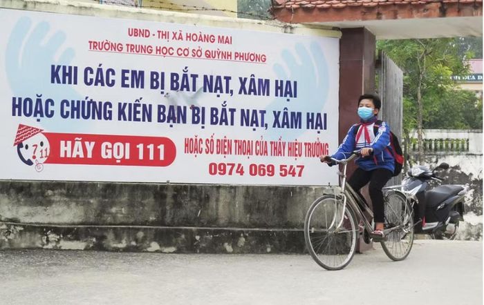 Băng rôn kèm số điện thoại thầy Hiệu trưởng trước cổng Trường THCS Quỳnh Phương.