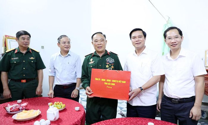 Đồng chí Lê Xuân Lợi tặng quà ông Hoàng Ngọc Cam.