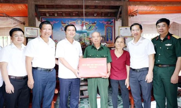 Đồng chí Lê Xuân Lợi cùng thành viên đoàn công tác tặng quà ông Ngô Quốc Hân.