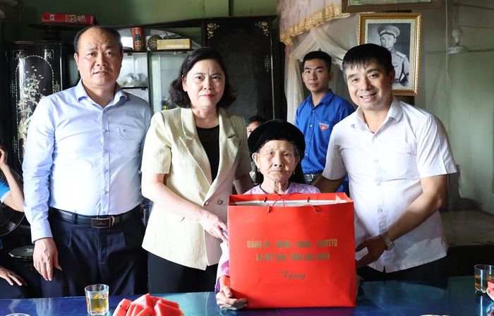  Đồng chí Trần Thị Hằng và đoàn công tác tặng quà bà Nguyễn Thị Chính. 