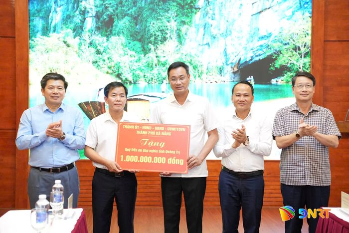 Bí thư Thành ủy Lê Ngọc Quang (giữa) trao biểu trưng hỗ trợ 1 tỷ đồng của thành phố Đà Nẵng cho Quỹ Đền ơn đáp nghĩa tỉnh Quảng Trị. Ảnh: T.CÔNG