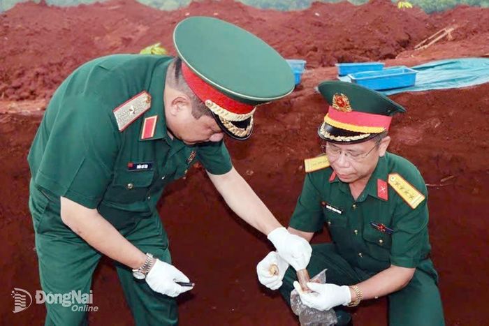Thủ trưởng Quân khu 7 và Bộ Chỉ huy Quân sự thành phố xem xét các di vật tìm thấy tại xã Minh Đức. Ảnh: ĐVCC