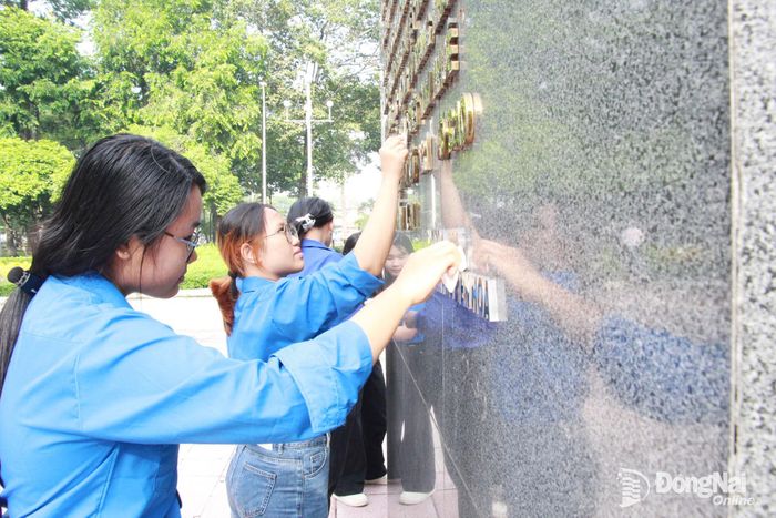 Đoàn viên, học sinh ra quân lau dọn, vệ sinh tại Tượng đài chiến thắng Long Bình. Ảnh: Nga Sơn