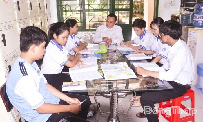 Thầy Phạm Văn Thông hướng dẫn Hữu Trí và các bạn trong đội tuyển học sinh giỏi môn Địa lý của trường.