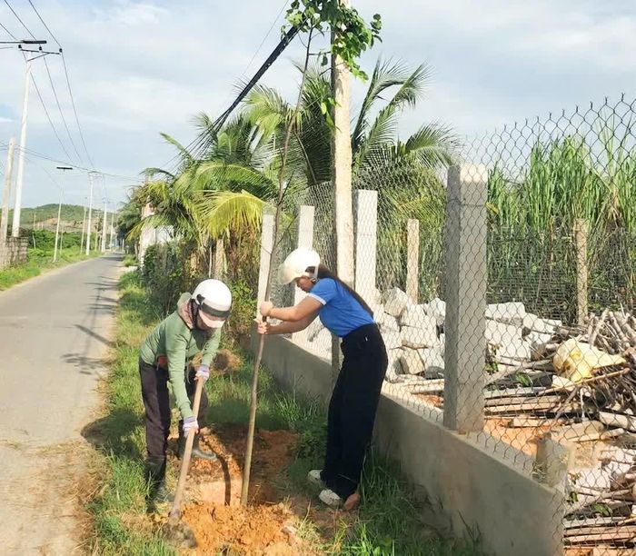 Cán bộ, hội viên phụ nữ trồng cây trên tuyến đường tại thôn Xuân Tây.