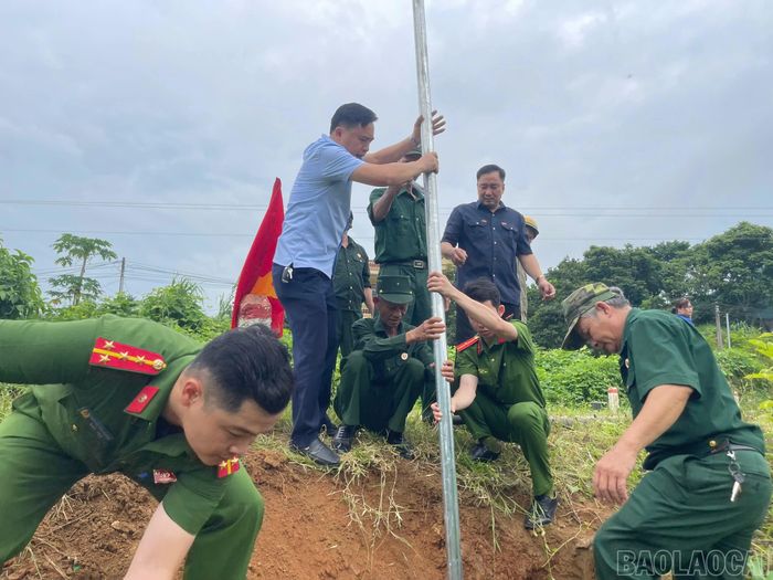 Các lực lượng tham gia dựng đèn năng lượng mặt trời trên tuyến đường tại thôn Liên Hà 5, xã Bảo Hà.