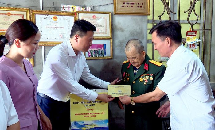 Phó Chủ tịch Thường trực Ủy ban MTTQ Việt Nam tỉnh Hà Đức Minh tặng quà thương binh Triệu Đình Vượng, thôn Đá Bia.