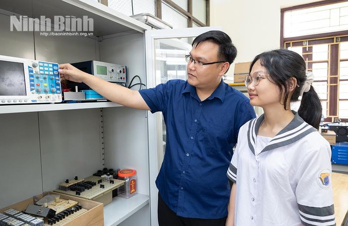 Thầy giáo Nguyễn Hải Dương và Nguyễn Thị Bích Ngọc kiểm tra thông số trên thiết bị đo lường điện tử.