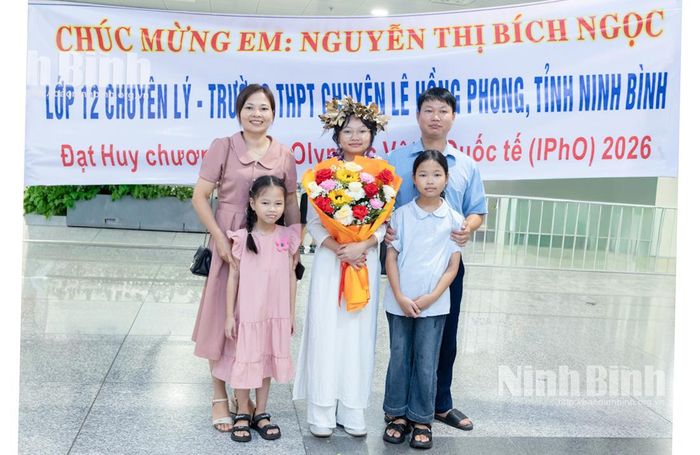 Em Nguyễn Thị Bích Ngọc, học sinh Trường THPT chuyên Lê Hồng Phong chụp ảnh lưu niệm cùng gia đình khi vừa trở về nước.