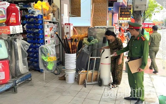 Công an xã vận động người dân tháo dỡ mái che vi phạm và ký cam kết không lấn chiếm vỉa hè.