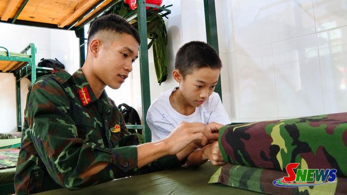 Chiến sĩ hướng dẫn các em gấp chăn màn