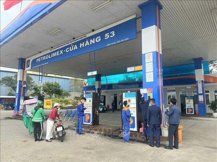 Lực lượng Quản lý thị trường dán số điện thoại đường dây nóng tại các cửa hàng xăng dầu trên bộ. Ảnh: Thanh Vân/TTXVN