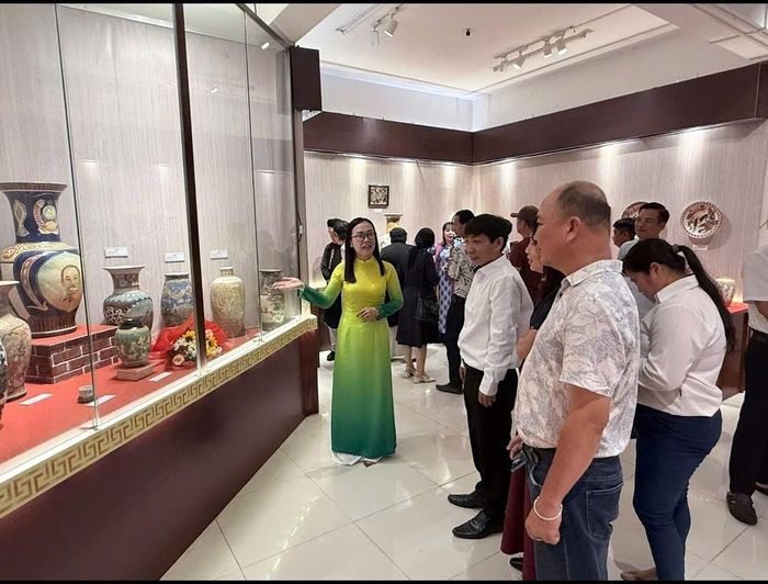 Du khách được thuyết minh viên giới thiệu hiện vật trưng bày tại bảo tàng