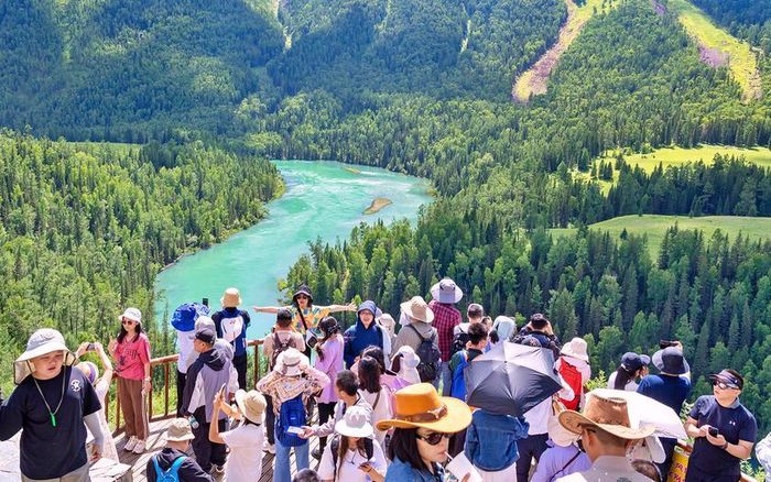 Altay (thuộc Khu tự trị Duy Ngô Nhĩ Tân Cương) là một khu nghỉ dưỡng mùa hè lý tưởng, với nhiệt độ trung bình 15 - 25℃, cùng cảnh quan đồng cỏ xanh mướt phủ đầy hoa dại, các hồ nước trong vắt mát lạnh. Trong ảnh là khách du lịch ngắm cảnh sông Kanas ở phía bắc Altay. Ảnh: China Daily