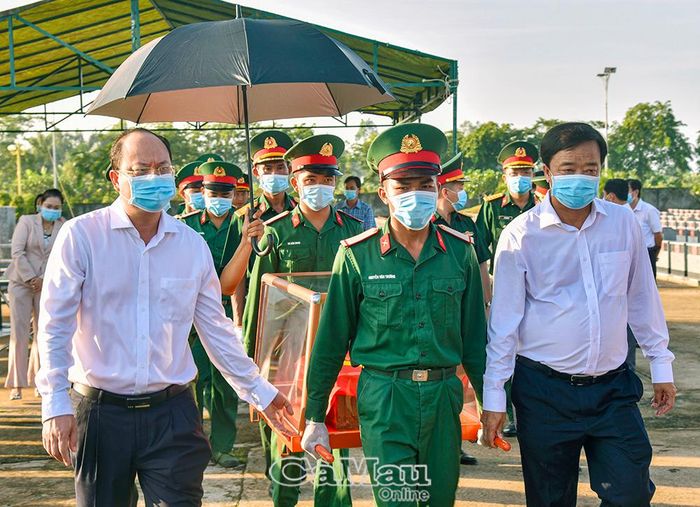 Bí thư Tỉnh ủy Nguyễn Hồ Hải (bìa trái) và Phó Bí thư Thường trực Tỉnh ủy Huỳnh Quốc Việt (bìa phải) tham gia nghi thức vận chuyển hài cốt liệt sĩ.