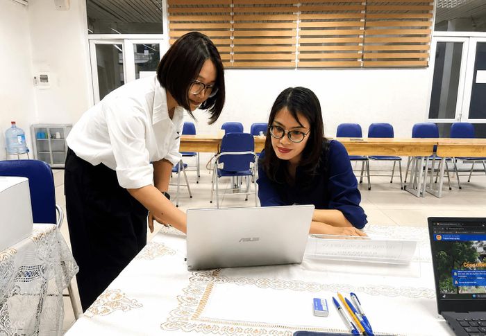 Chị Nguyễn Thị Thu Huyền được giáo viên trường cấp 2 Nguyễn Lân, phường Thanh Liệt hướng dẫn cụ thể từng bước kiểm tra thông tin và thao tác trên hệ thống. Ảnh: Đào Tuyết