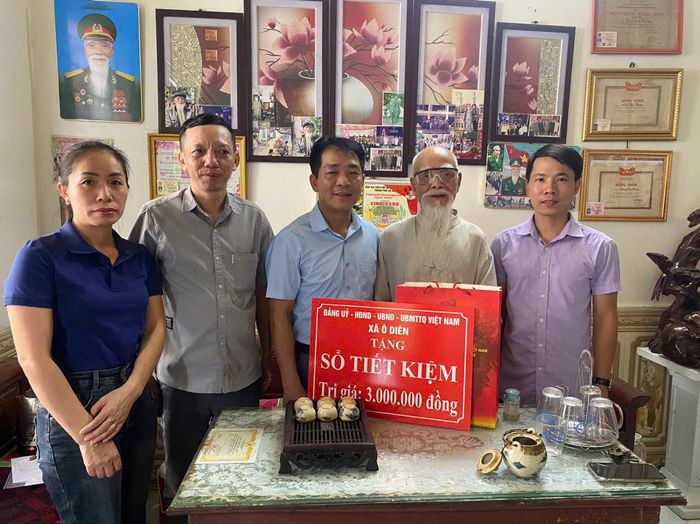 Ông Uông Văn Hường nhận sổ tiết kiệm và quà tri ân từ đoàn công tác xã Ô Diên. Ảnh: Đinh Hiền