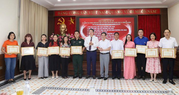 Bí thư Đảng ủy, Chủ tịch HĐND phường Cửa Nam Nguyễn Hoàng Trường và TS. Vũ Lộc An - Phó Hiệu trưởng Trường Đào tạo cán bộ Lê Hồng Phong khen thưởng các tập thể có thành tích trong triển khai Cuộc thi chính luận về bảo vệ nền tảng tư tưởng của Đảng lần thứ Sáu, năm 2026. Ảnh: PV