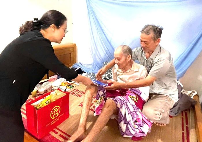 Phó Bí thư Thường trực Đảng ủy phường Tây Tựu Nguyễn Thị Nắng Mai tặng quà gia đình chính sách, người có công. Ảnh TT