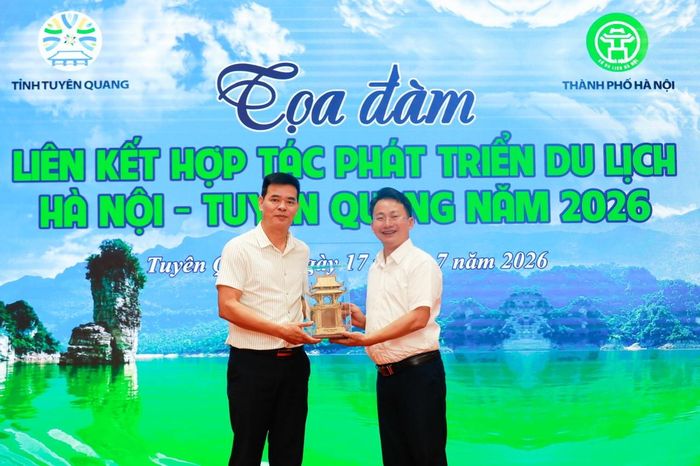 Lãnh đạo ngành Du lịch Hà Nội và Tuyên Quang cùng tặng những món quà lưu niệm đặc trưng của từng địa phương. Ảnh: Việt Cường