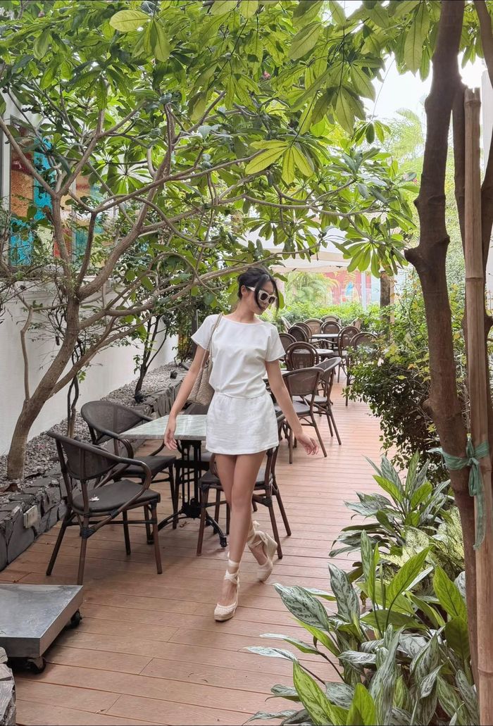 Bà xã Đoàn Văn Hậu phối cùng túi xách da màu kem, kính trắng và đôi giày cao Gothic buộc dây đồng màu. Phụ kiện cùng tông giúp tổng thể trở nên hài hòa, đúng tinh thần “yên tĩnh sang trọng” (quiet luxury) - xu hướng thời trang quốc tế.