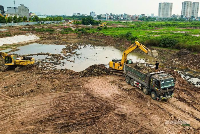 Máy móc đào, vận chuyển đất tại lòng hồ.