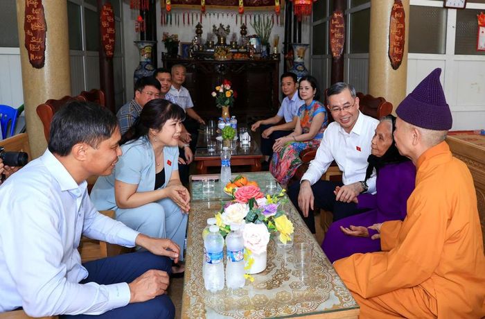 Bộ trưởng cùng đoàn công tác thăm hỏi và tặng quà Mẹ liệt sĩ Vũ Thị Hiển, thân mẫu của liệt sĩ Đinh Ngọc Quang. Ảnh: MOF.