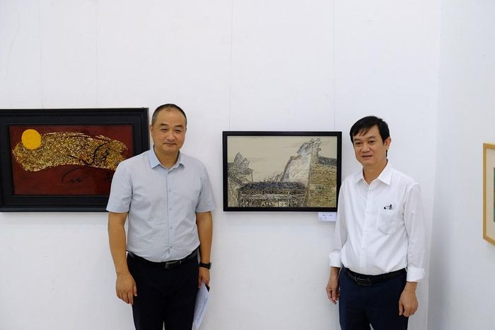 GS.TS Vương Nghi - Phó Viện trưởng Viện Mỹ thuật thuộc Đại học Sư phạm An Huy (bên trái) và TS Ngô Việt Hùng - Hiệu trưởng Trường Đại học Mỹ thuật TP.HCM tại triển lãm