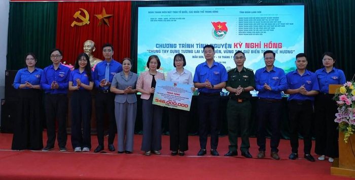 Ban Tổ chức trao biển tượng trưng tổng nguồn lực chương trình tình nguyện Kỳ nghỉ hồng