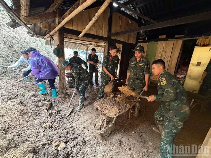 Vận chuyển đất đá ra khỏi khu vực nhà dân bị sạt lở.