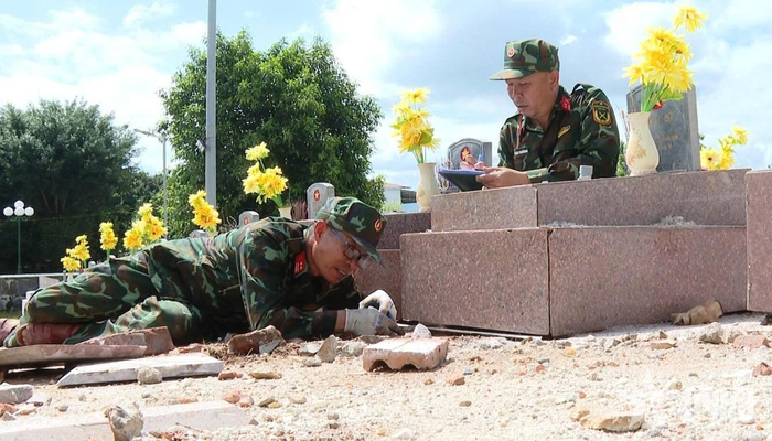 Trung tá QNCN Nguyễn Văn Ngọc trực tiếp đo kích thước từng phần mộ để phục vụ công tác hoàn nguyên.