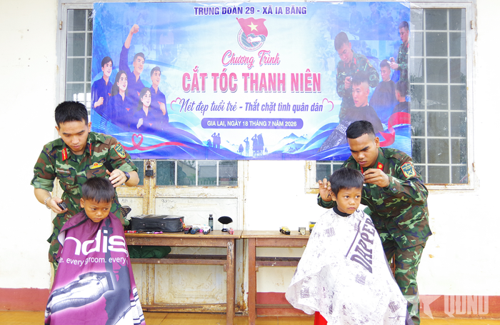 Chiến sĩ Trung đoàn 29 cắt tóc cho các em nhỏ.