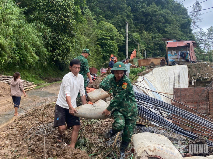 Cán bộ, chiến sĩ Đồn Biên phòng Ka Lăng, Bộ đội Biên phòng tỉnh Lai Châu giúp gia đình anh Chu Té Hừ di dời vật liệu và thiết bị xây dựng.