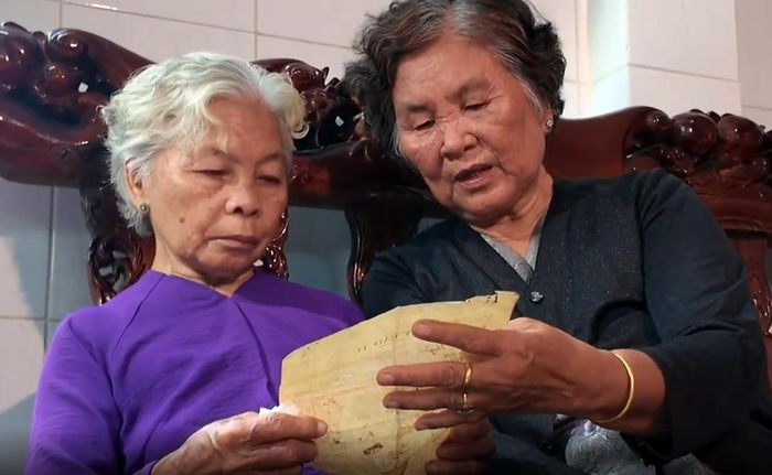 Bà Nguyễn Thị Lệ và bà Huỳnh Thị Lê xem kỷ vật của liệt sĩ Huỳnh Văn Quên