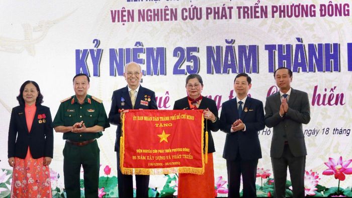 Phó Chủ tịch HĐND TPHCM Huỳnh Thanh Nhân (bìa phải) thay mặt Chủ tịch UBND TPHCM tặng Cờ truyền thống cho Viện Nghiên cứu phát triển Phương Đông