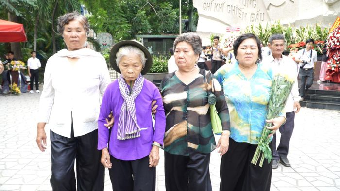 Bà Nguyễn Thị Lệ (áo tím) cùng gia đình thân nhân liệt sĩ Huỳnh Văn Quên đến viếng tại Công viên Lê Thị Riêng ngày 13-7. Ảnh: THANH CHIÊU