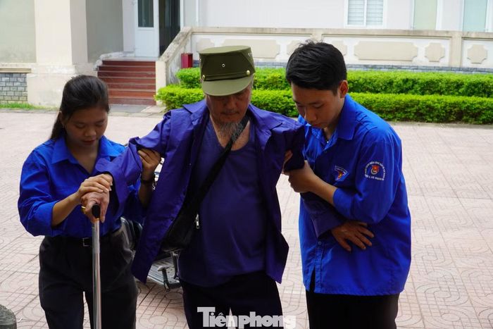 Đoàn viên thanh niên dìu thương binh đến khu vực khám sức khỏe trong chương trình tri ân.