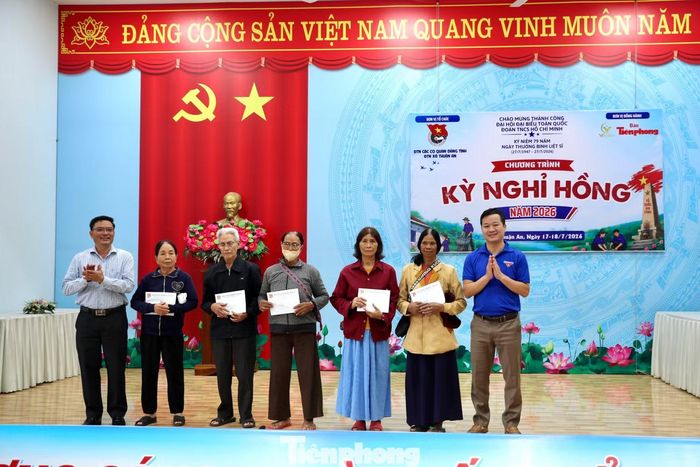 Anh Nguyễn Quảng Lâm - Bí thư Đoàn Thanh niên Các cơ quan Đảng tỉnh Lâm Đồng (bên phải) và ông Nguyễn Tiến Phúc - Phó Bí thư Thường trực Đảng ủy xã Thuận An (bên trái), tặng quà các hộ dân khó khăn.