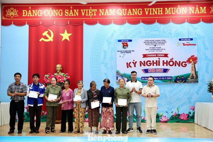 Ông Nguyễn Thành Nam - Phó Chủ tịch UBND xã Thuận An (bên trái), phóng viên Thái Lâm - Văn phòng đại diện Báo Tiền Phong khu vực Tây Nguyên - Nam Trung Bộ (thứ 2 từ phải qua) và anh Huỳnh Quang Việt - CEO Công ty TNHH Vietera Entertainment (bên phải) trao tặng quà cho các hộ khó khăn.