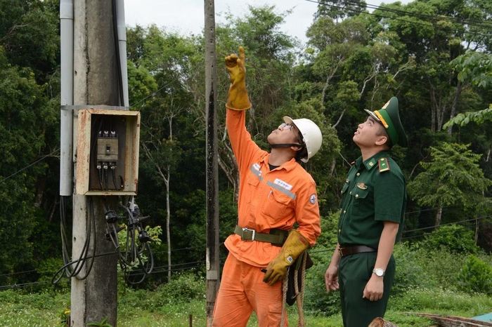 Nhân viên điện lực Tuy Đức và chỉ huy Đồn Biên phòng cửa khẩu Bu P’răng phối hợp kiểm tra lưới điện nơi biên giới. (Ảnh: Đại Dương)