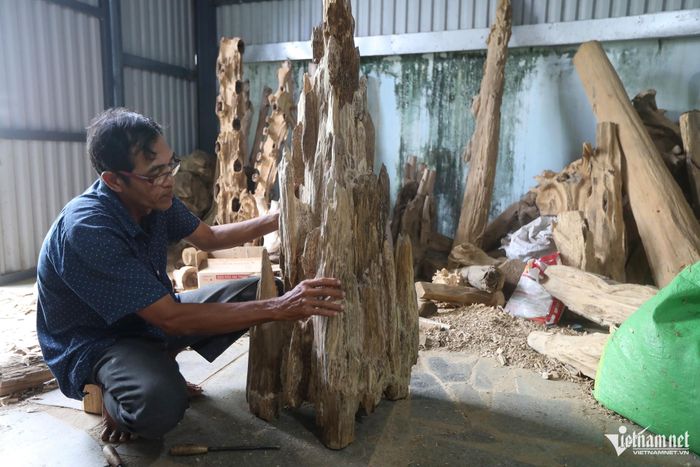 Ông Sáu Thời đang soi phôi dó bầu nặng khoảng 10kg, cao chừng 80cm, bề ngang 50cm. Ảnh: Xuân Ngọc