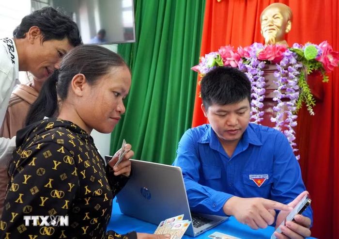 Người dân tộc Cor ở thôn Trà Thanh, xã Thanh Bồng (Quảng Ngãi) được thành viên Tổ công tác lưu động hỗ trợ thực hiện thủ tục hành chính. (Ảnh: Lê Phước Ngọc/TTXVN)