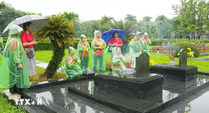 Sáng 18/7, dù thời tiết không thuận lợi nhưng đông đảo người dân địa phương và du khách đã đến nghĩa trang A1 để thắp hương tưởng nhớ, tri ân các Anh hùng liệt sỹ. (Ảnh: Phan Quân/TTXVN)