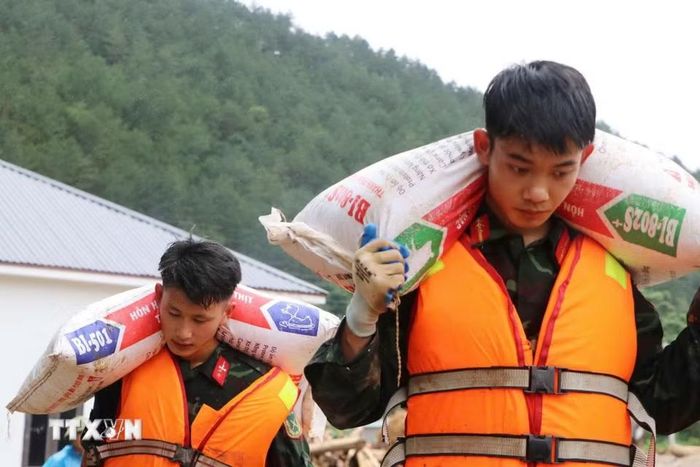 Các lực lượng cứu hộ của tỉnh Lai Châu giúp người dân Mường Than di dời tài sản đến nơi an toàn. (Ảnh: Nguyễn Oanh/TTXVN)