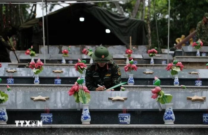 Một chiến sỹ thực hiện quy trình lưu trữ thông tin các phần mộ liệt sĩ trước khi khai quật lấy mẫu giám định ADN. (Ảnh: Nguyễn Dũng/TTXVN)